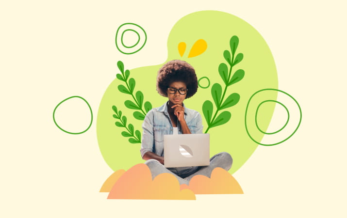A young woman working on a laptop surrounded by green plants