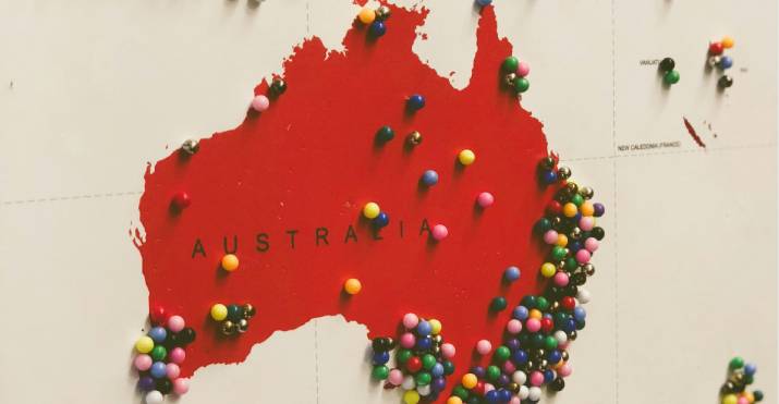 A red map of Australia covered in pins to illustrate the different locations that students may come from