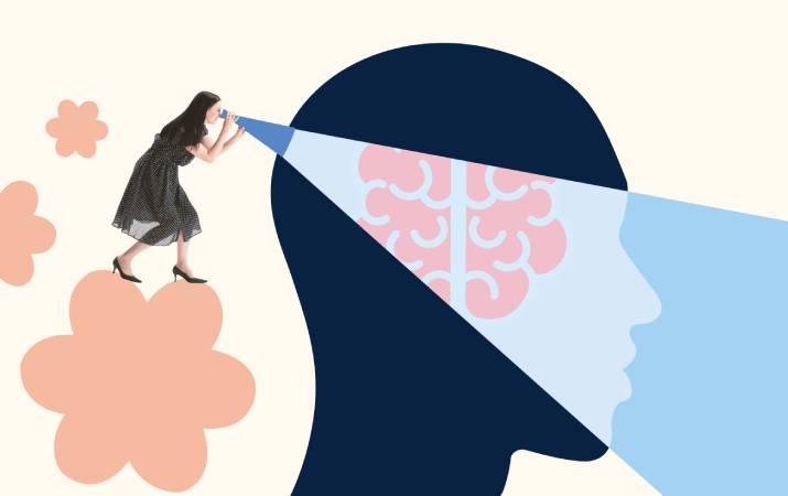 A woman peering into a head with spotlight on the brain